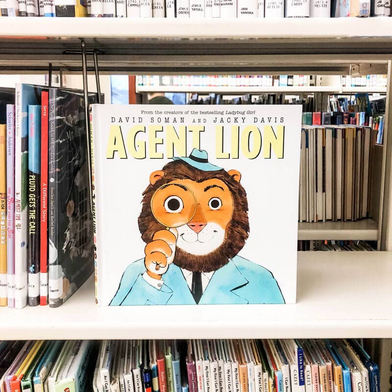 The picture book agent lion on a library bookshelf