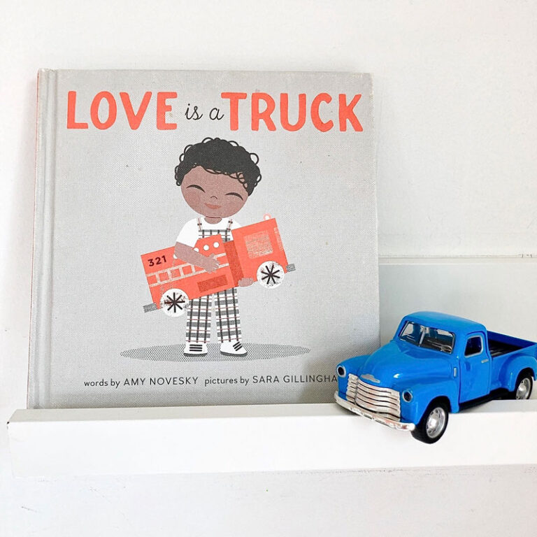 "Love is a Truck" book on a shelf next to a blue toy truck