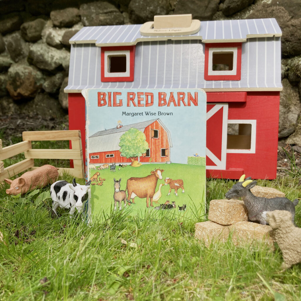 children's book in front of a toy wooden red barn