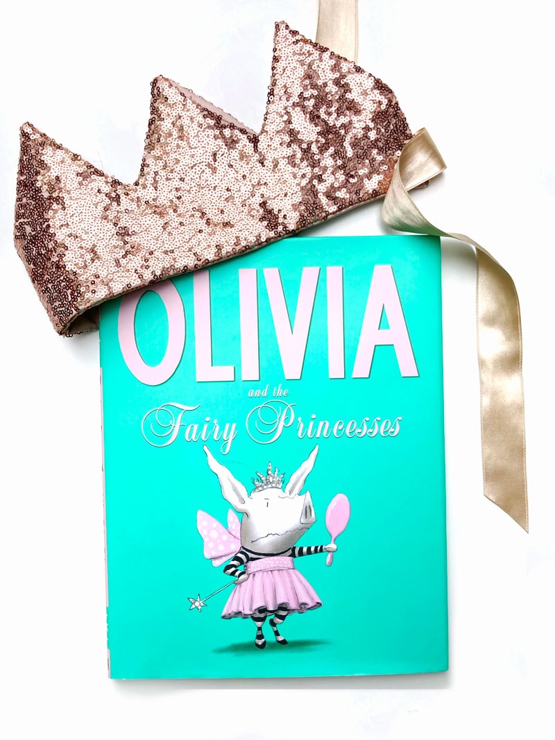 the book titled "Olivia" with a pink sequined crown laying on the top of the cover