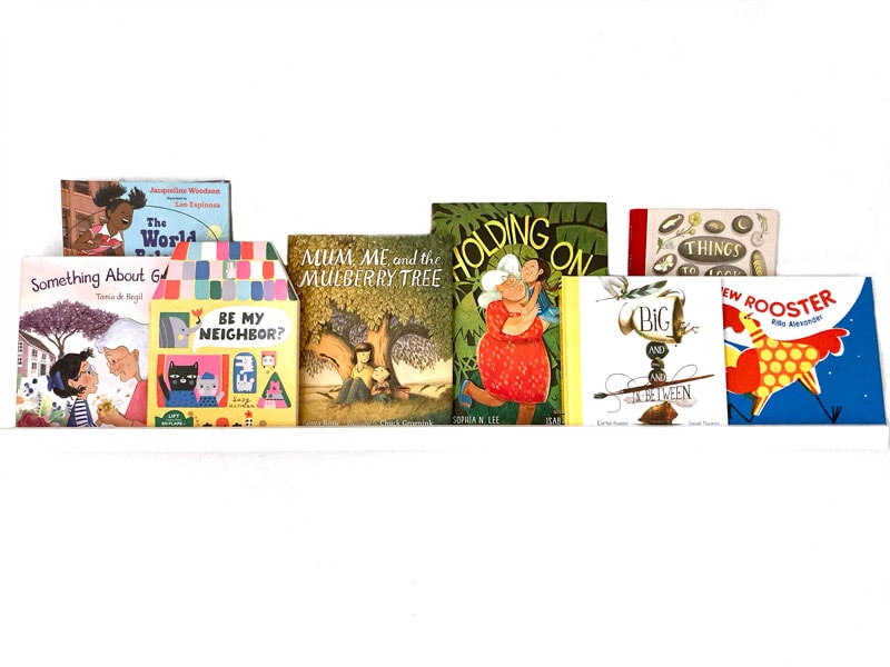 children's picture books on a white shelf and white background